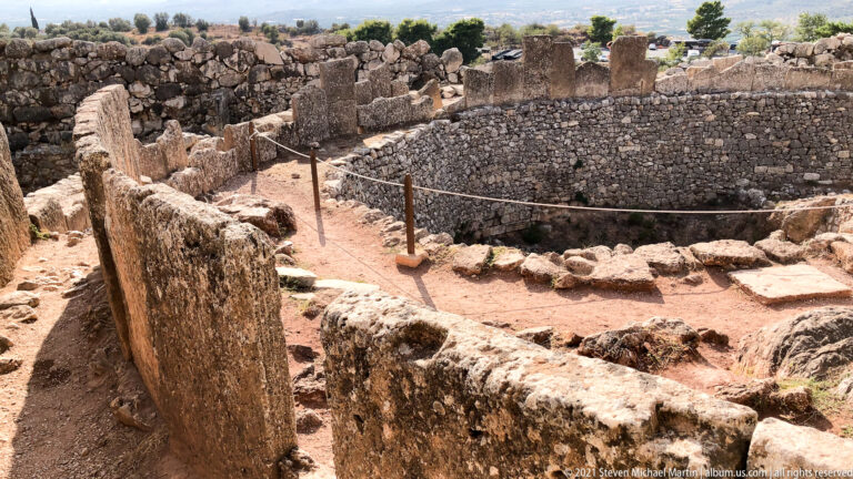 Upright grave stelae and foundations inside the circular stone enclosure of Grave Circle A at Mycenae.