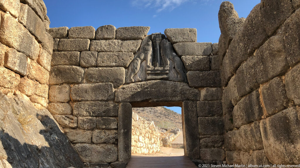 Lion Gate at Mycenae framed by Cyclopean masonry, with two confronted felines flanking a central column in the triangular relief.