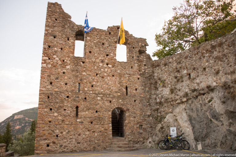 Front view of a stone fortified gateway at Mystras with steps leading to a small arched passage.