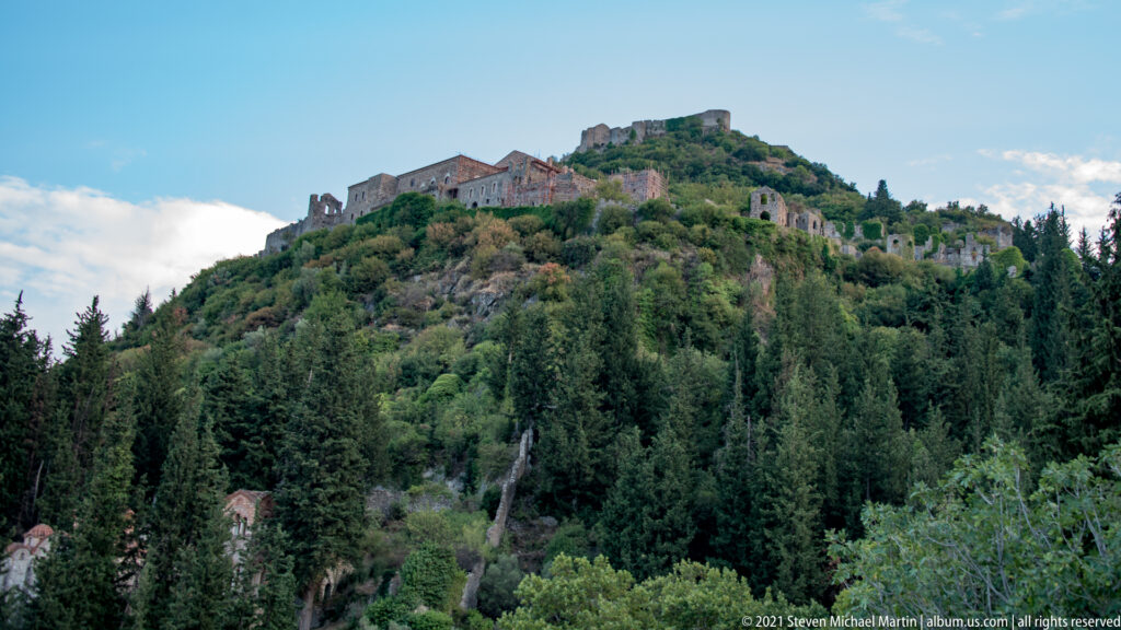 Upper Mystras with large palatial ruins on the slope and fortress walls crowning the summit.