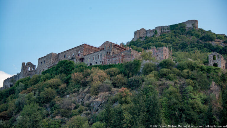 Closer view of the Palace of the Despots with scaffolding, arched openings, and fortress walls above.