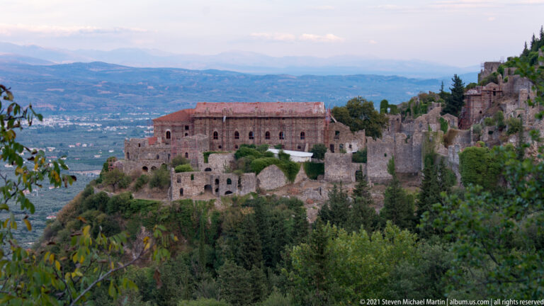 Wide view of the Palace of the Despots, surrounding stone fortifications, and valley beyond Mystras.