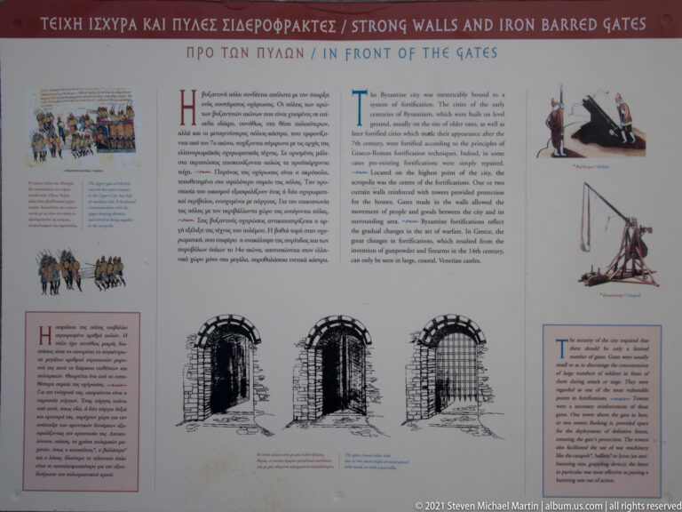 Interpretive panel on Mystras fortifications, with gate diagrams, armed figures, and bilingual Greek and English text.