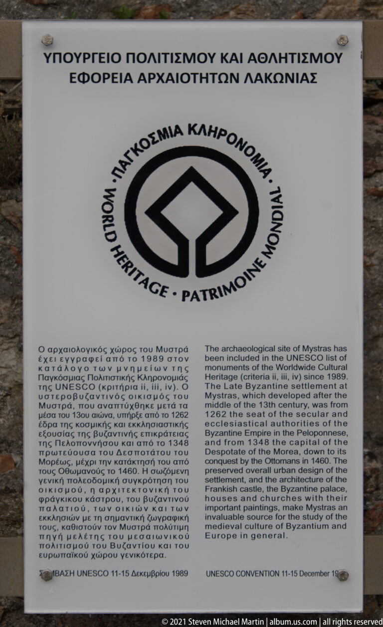 UNESCO World Heritage plaque at Mystras with the World Heritage emblem and bilingual Greek and English inscription text.
