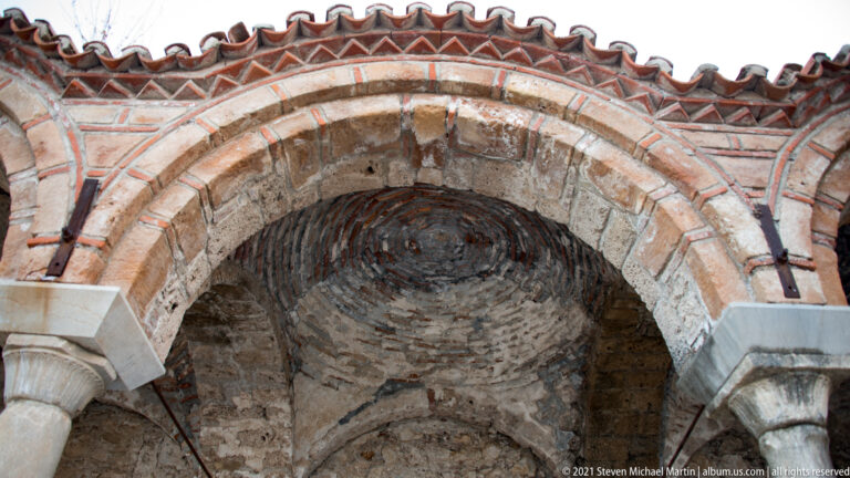 Concentric brick-and-stone arches above stone columns inside St. Sophia at Mystras.