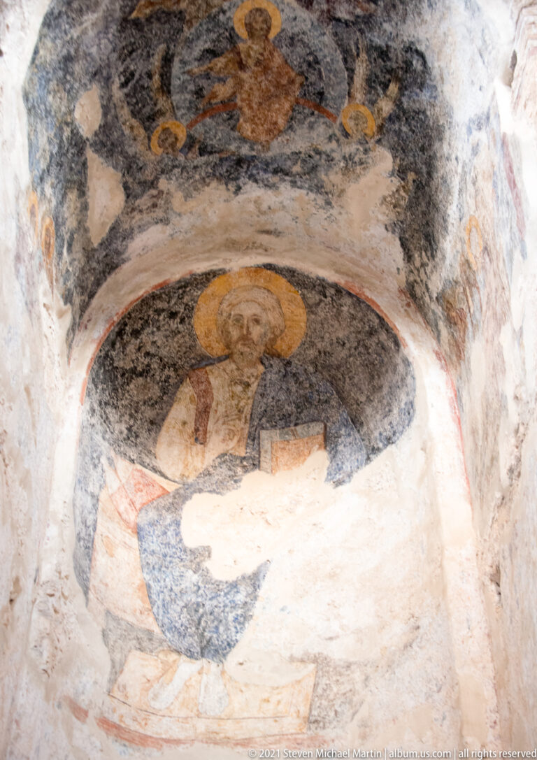 Second view of a weathered frescoed niche in St. Sophia with a central haloed figure and fragmentary figures above.