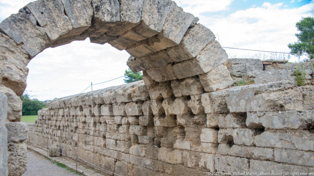 Stone-vaulted Krypte passage leading through the embankment toward the ancient Stadium of Olympia.