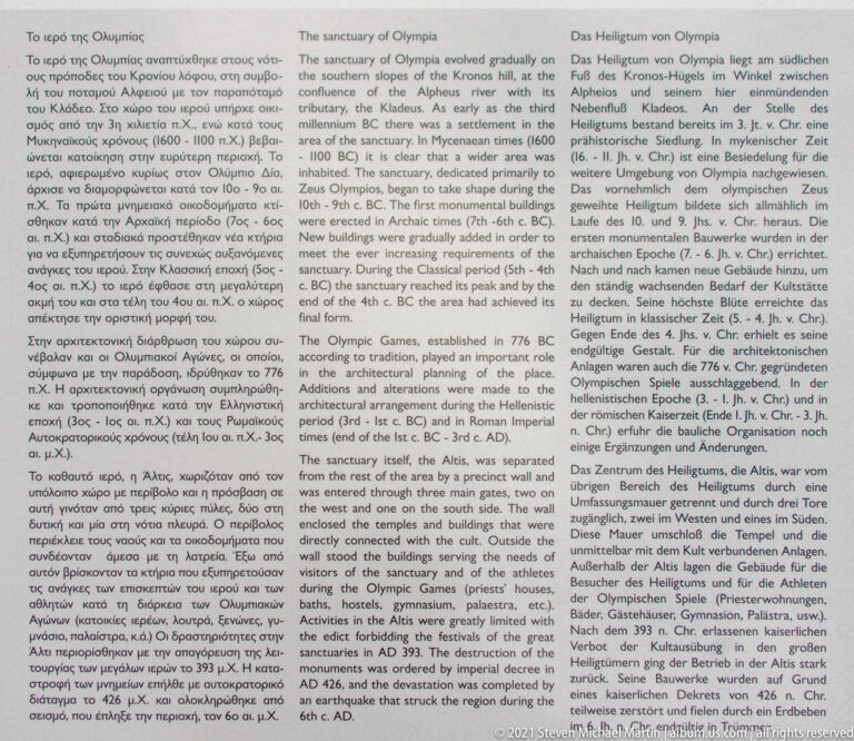 Large multilingual interpretive panel headed with information about the Sanctuary of Olympia.
