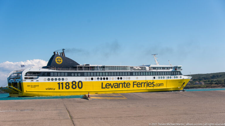 Side view of a yellow-and-white Levante Ferries passenger ship docked beside a concrete quay.