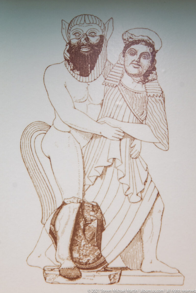Line drawing of two bearded ancient athletes grappling in a wrestling hold.
