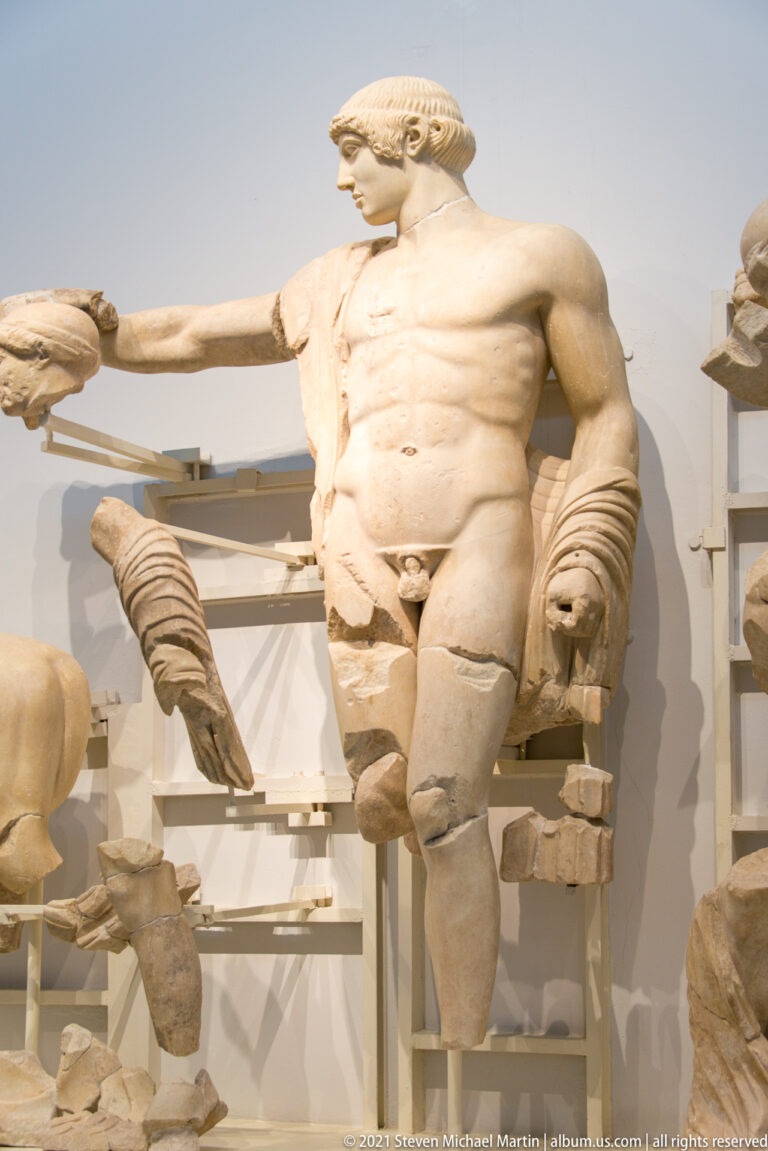 Muscular marble male figure extending one arm in the reconstructed Temple of Zeus west pediment.