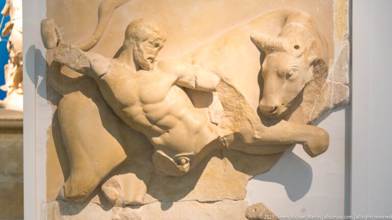 Marble metope from the Temple of Zeus showing Herakles grappling with the Cretan Bull.