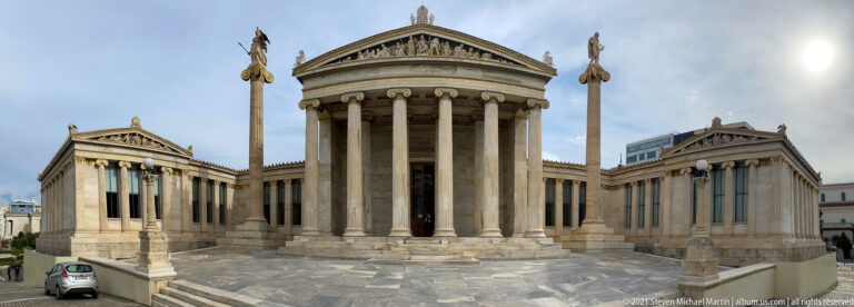 Academy of Athens with central Ionic portico, sculpted pediment, flanking wings, and two tall statue-topped columns.