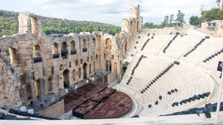 Semicircular marble auditorium and stage of the Odeon of Herodes Atticus viewed from above.