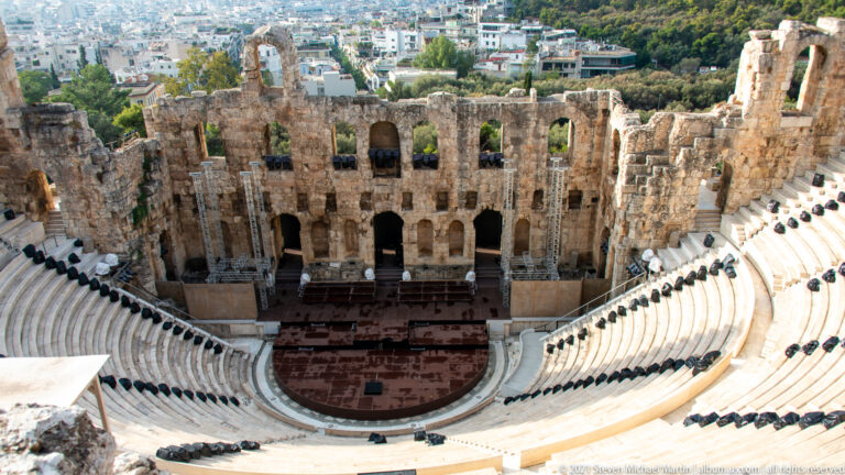 Centered overhead view of the Odeon of Herodes Atticus, showing marble seating, stage, and tall arched stage wall.