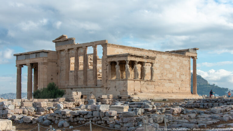 Oblique overview of the Erechtheion with columned porches, high marble walls, and the Porch of the Caryatids.