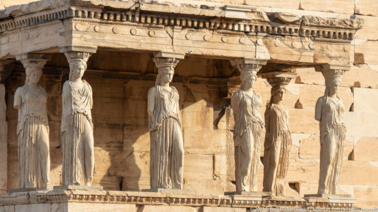 Close view of the six Caryatid copies supporting the south porch of the Erechtheion beneath its carved entablature.