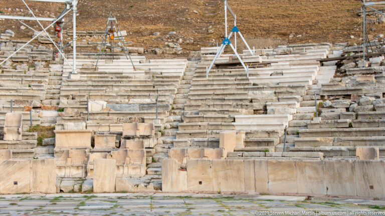 Marble seating and stairways of the Theatre of Dionysus, with conservation supports and scaffolding across the cavea.