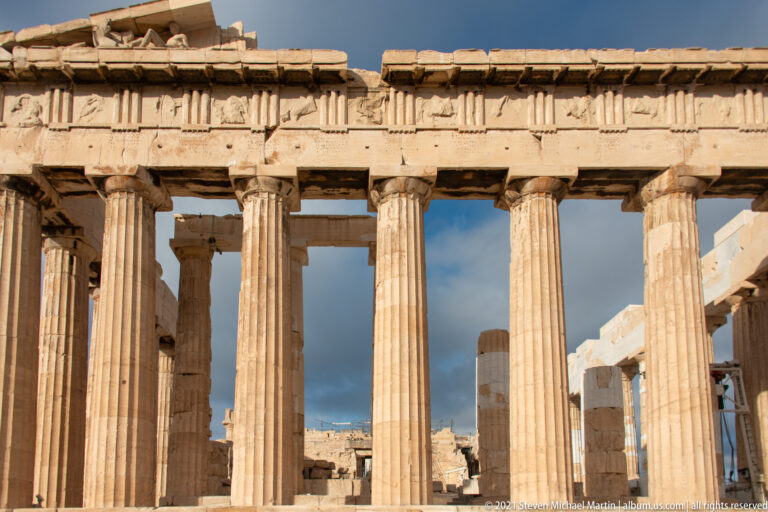 Close frontal view of the Parthenon’s Doric columns and weathered entablature, with additional masonry visible between the shafts.