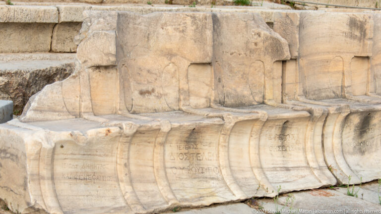 Close view of carved and inscribed marble front-row seats in the Theatre of Dionysus.