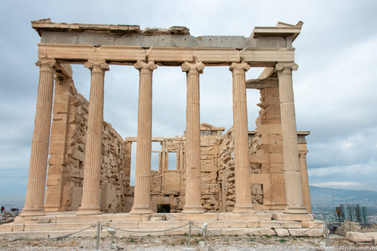 Frontal view of the Erechtheion’s north porch with six tall Ionic columns and masonry walls visible behind.