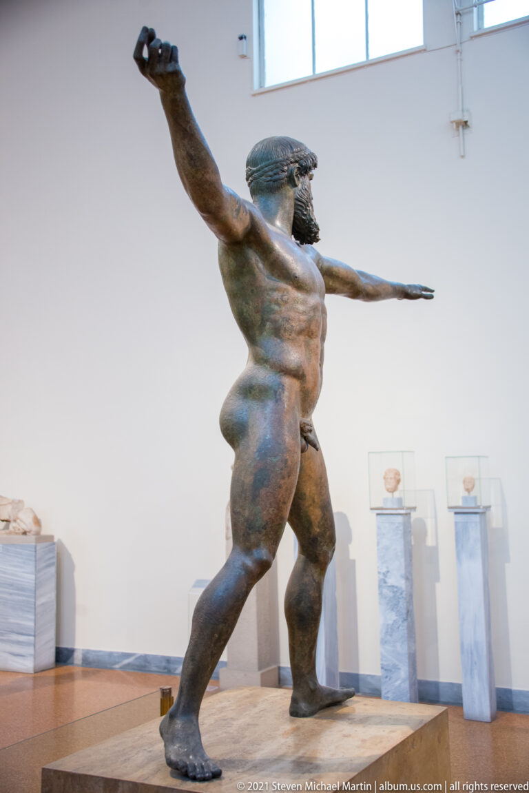 Three-quarter view of Zeus or Poseidon of Artemision with outstretched arms, turning torso, and widely planted legs.