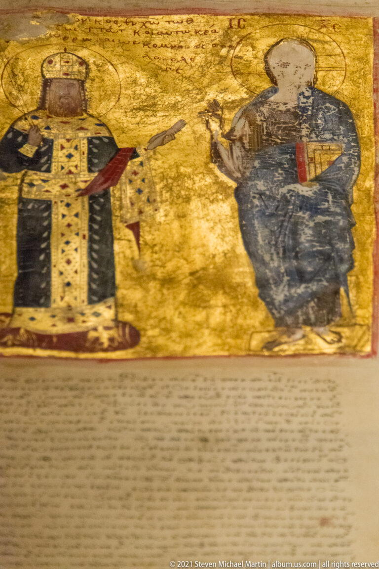Two haloed figures on a gold ground above closely written Greek text on a manuscript page.