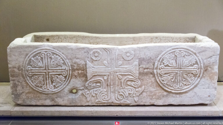 Rectangular carved marble container with an open top and three cross designs across its front face.
