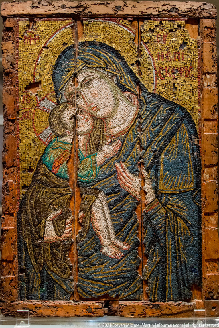 Mosaic of the Virgin embracing the Christ Child, with blue mantle, gold ground, and visibly worn panel edges.