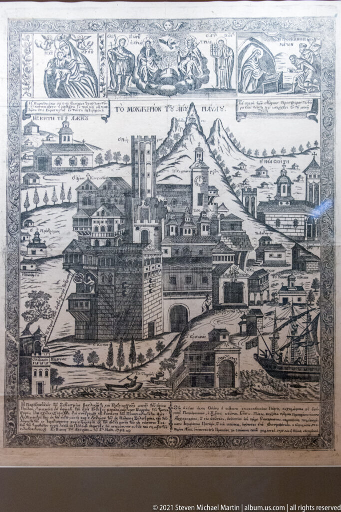 Black-and-white engraving of a fortified monastic settlement with towers, churches, mountains, ships, upper narrative scenes, and inscriptions below.