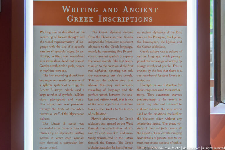 Tall museum panel headed “Writing and Ancient Greek Inscriptions,” filled with explanatory text.