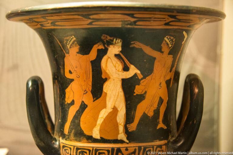 Handled black-glazed vessel with three painted figures, including a pale central figure.