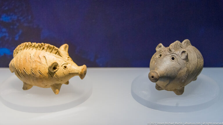 Two small ceramic boar-shaped vessels displayed side by side.