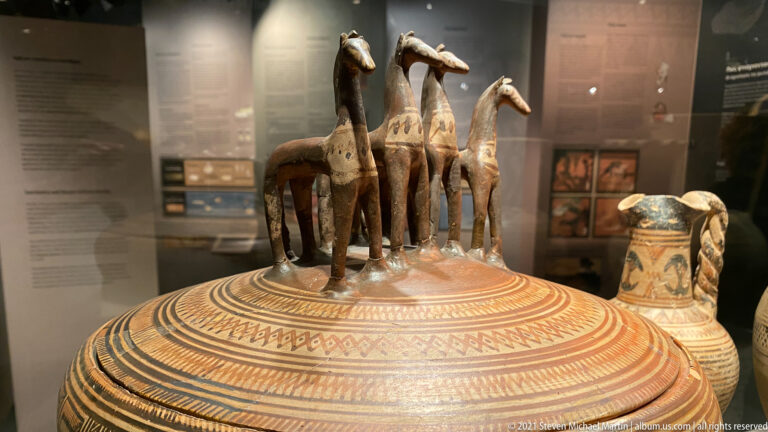 Large Late Geometric Attic pyxis with dense painted bands and four horse figurines standing on its lid.