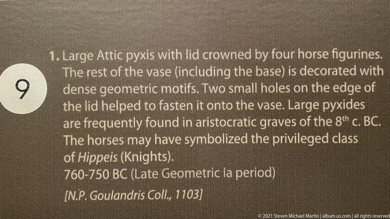 Museum label identifying a large Attic pyxis with four horse figurines, dated 760–750 BC.
