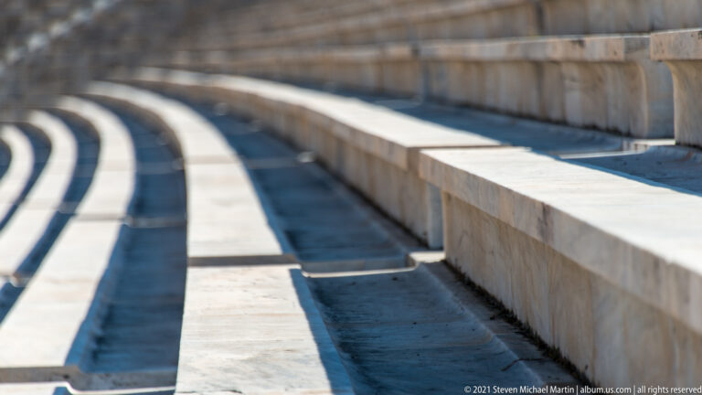 Shallow-focus detail of curved marble benches and a recessed passage at the Panathenaic Stadium.