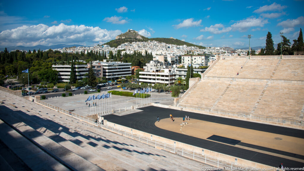 Elevated view over the Panathenaic Stadium track and marble stands toward Athens and Mount Lycabettus.