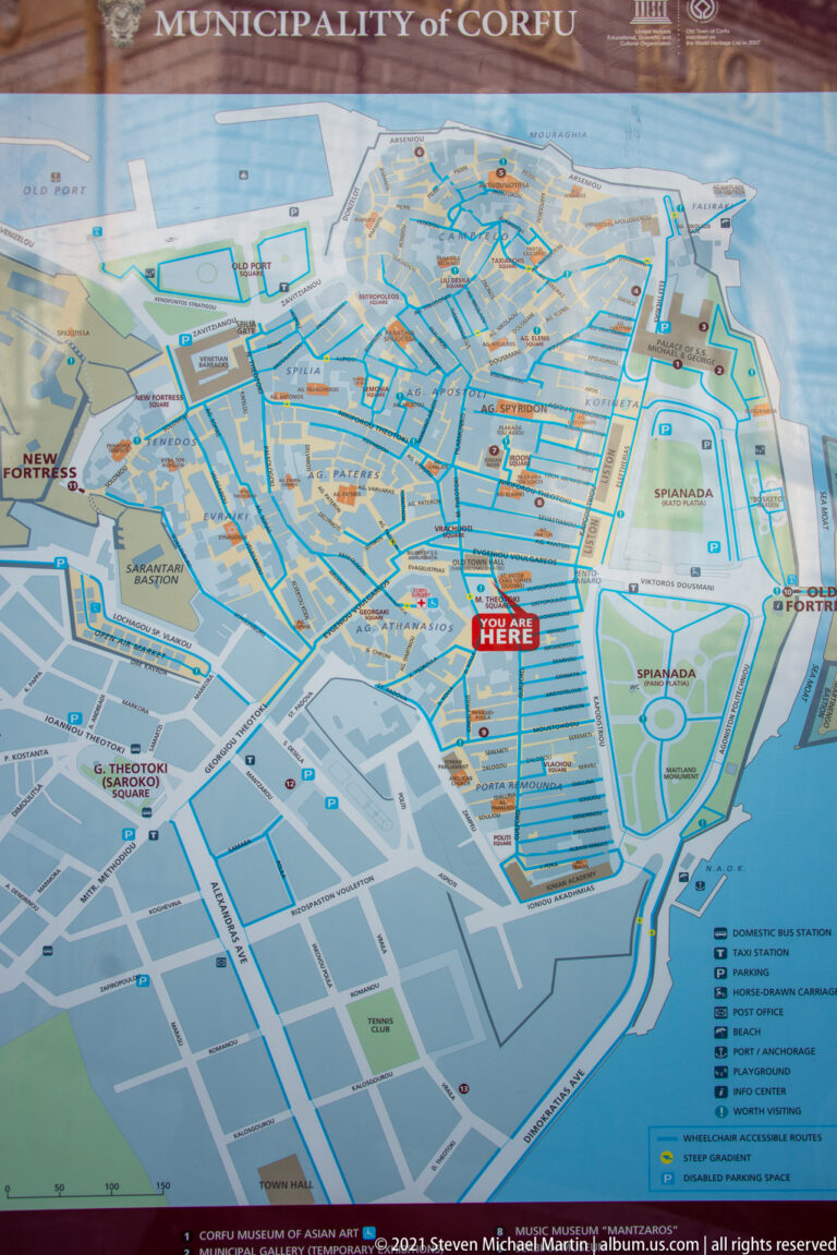 Public Municipality of Corfu map showing the historic center, waterfront, streets, green spaces, routes, and numbered sites.
