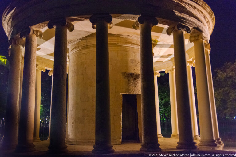 Night view through the Ionic columns of the 1816 Maitland Rotunda around its cylindrical core in Spianada Square.