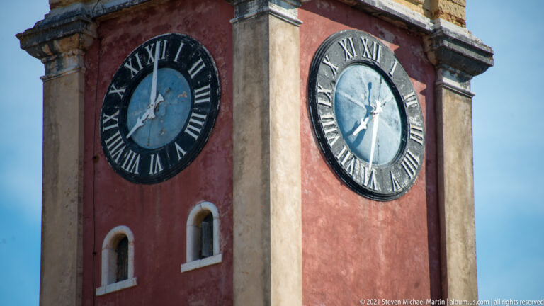 Two Roman-numeral clock faces on the British-period clock tower of Corfu’s Old Fortress.