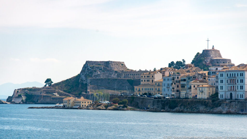 Corfu's Old Fortress on a rocky promontory beside the historic waterfront and clustered town buildings.
