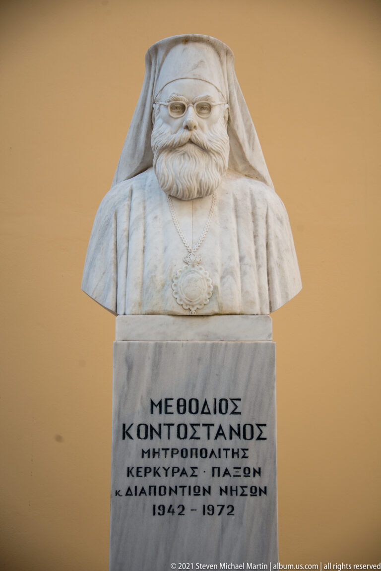 White marble bust of bearded Orthodox cleric Methodios Kontostanos above a Greek-inscribed pedestal dated 1842–1922.