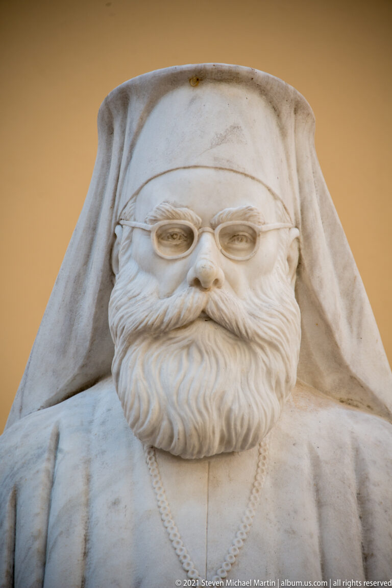 Close detail of Methodios Kontostanos marble bust showing eyeglasses, full carved beard, clerical head covering, and chest chain.