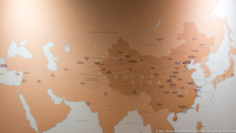 Earth-toned museum map of Asia centered on China, with country names, cities, and cultural-site markers across the continent.