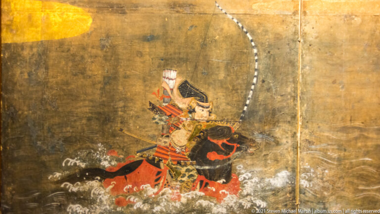 Armored Japanese warrior on a dark horse moving through stylized waves, carrying a long curved bow against a gold ground.
