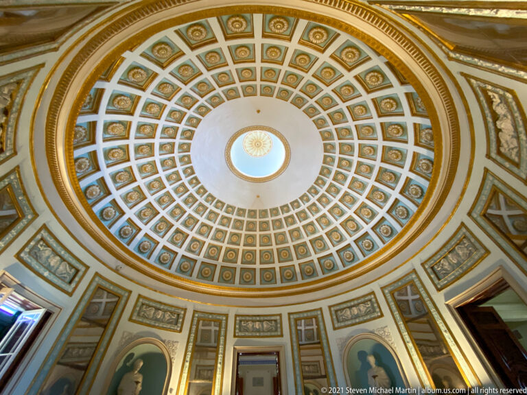 Coffered Rotunda dome in blue, white, and gold, rising above circular wall niches and converging on a round central oculus.