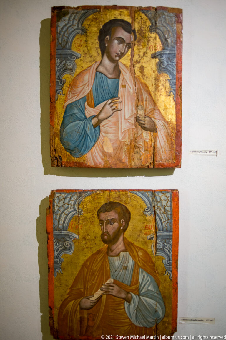 Two gold-ground icon panels of haloed apostles mounted vertically on a museum wall.
