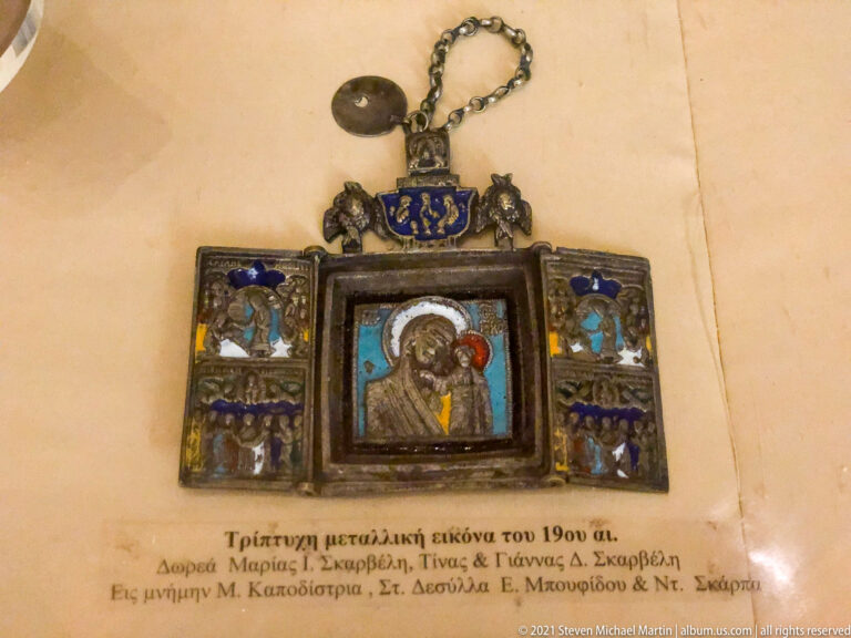 Small hinged devotional triptych with central Virgin and Child, miniature figures on side wings, blue accents, and suspension chain.