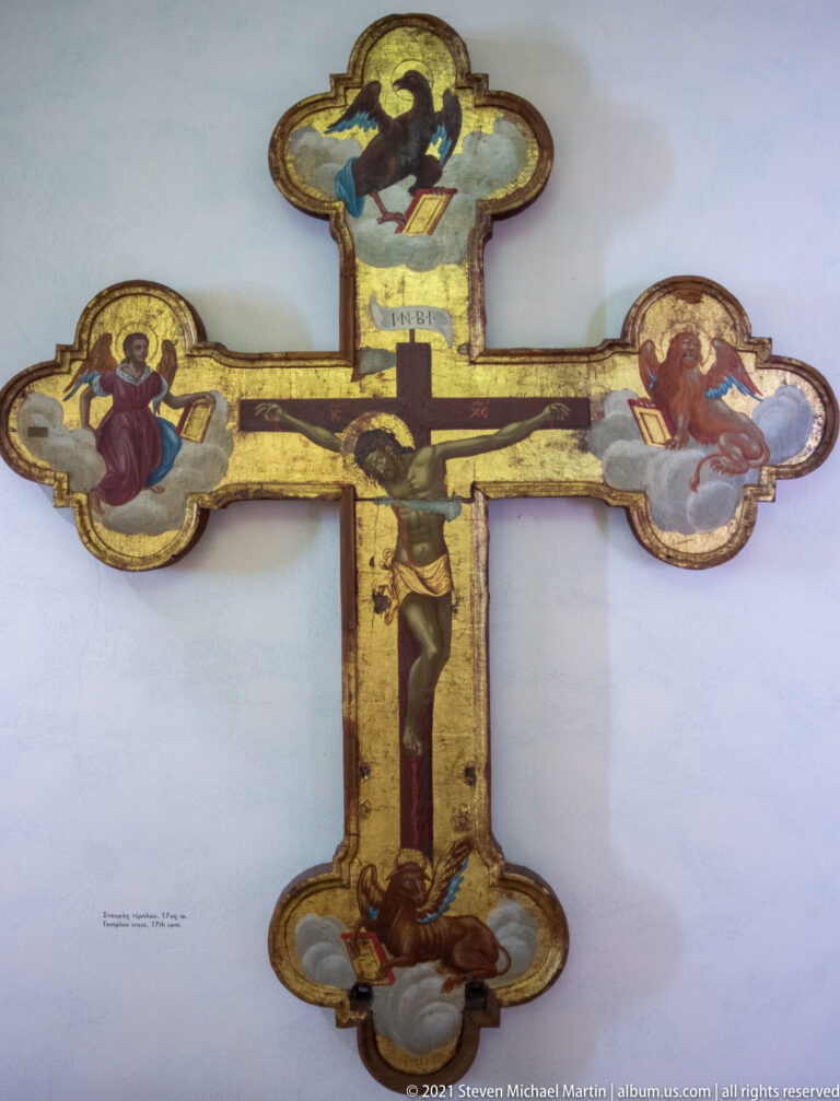 Painted crucifix with Christ on the cross and sacred figures in rounded terminals at the arms and ends.