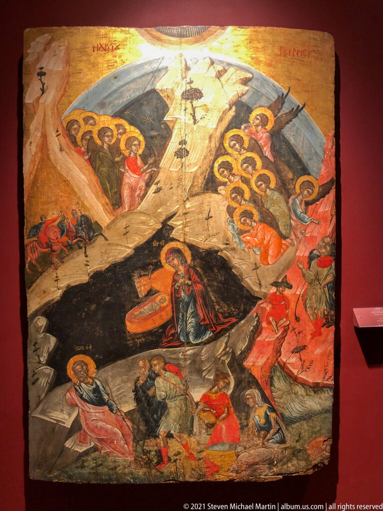 Crowded Passion icon centered on a tall Cross, with haloed groups at the sides and mourners in rocky terrain below.